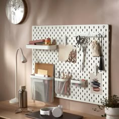 a white pegboard mounted to the side of a wall with office supplies on it