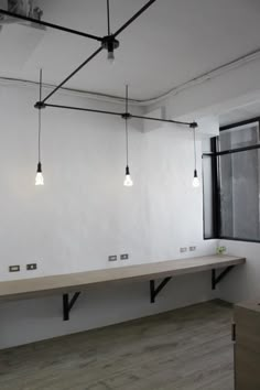 an empty room with several lights hanging from the ceiling and two benches on each side