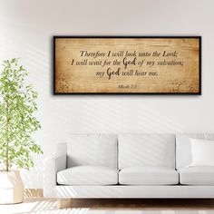 a living room with a white couch and a wooden framed wall hanging above it that says, there is a call look into the lord