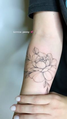 a woman's arm with a flower tattoo on the left side of her arm