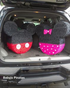 two mickey and minnie mouse ears sitting in the back of a car with its trunk open