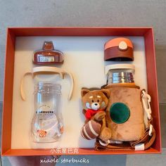 a brown teddy bear sitting inside of a box next to a cup and other items