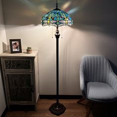 a blue chair sitting next to a lamp on top of a table