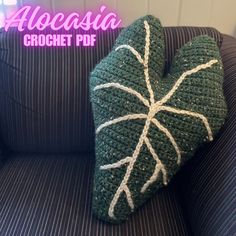 a green crocheted pillow sitting on top of a couch