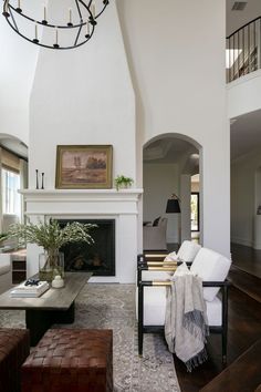 a living room with white furniture and a fireplace