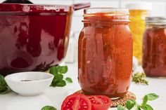 several jars filled with different types of sauces and garnishes on a table