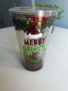 a merry grinmas cup with a straw in it