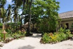 a house with lots of trees and plants around it