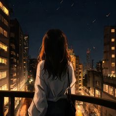 a woman standing on top of a balcony next to tall buildings at night with stars in the sky