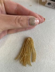 a woman's hand with gold beading on it