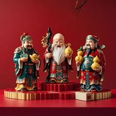 three small figurines sitting on top of a red table next to each other