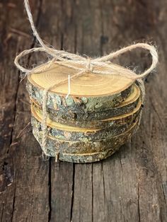 a stack of logs tied with twine on top of a wooden table next to a candle