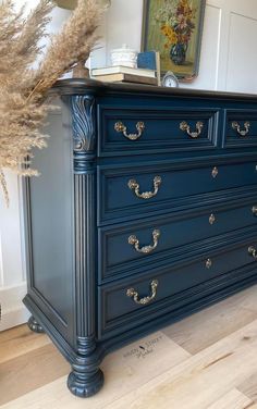 a blue dresser with gold handles in a room