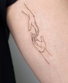 a woman's arm with a line drawing of two hands holding each other on it