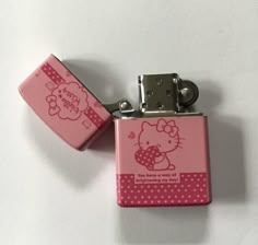 two pink hello kitty lighters sitting next to each other on top of a white surface