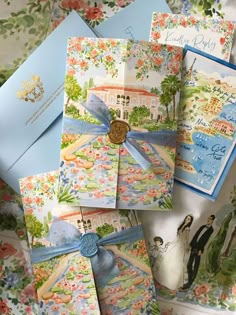 wedding stationery is laid out on top of each other with blue ribbon and matching envelopes