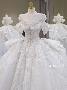 a white wedding dress on display in front of mannequins wearing gowns