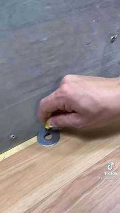 a person is using a tool to cut through the floor with a circular hole in it