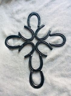 a cross made out of black metal scissors