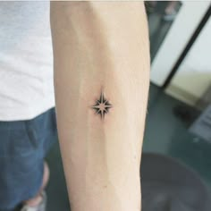 a small star tattoo on the arm