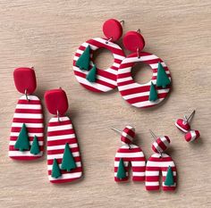 three pairs of red and white striped earrings with green trees on the front, two in the back