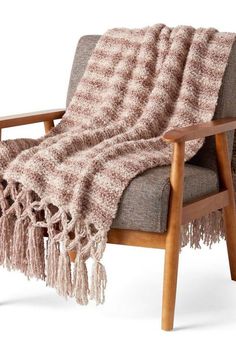 a chair with a blanket on it and a wooden frame around the armrests