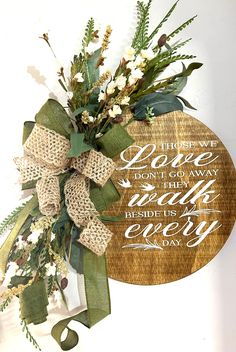 a wooden plaque with flowers and greenery on it