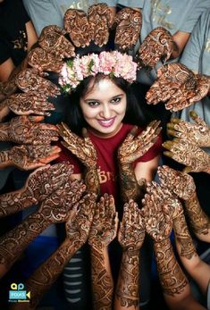 a woman with her hands covered in hendi and flowers on top of her head