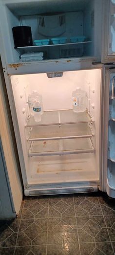 an open refrigerator with water and ice in it