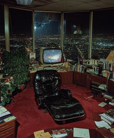 a living room filled with lots of furniture and a tv on top of a desk