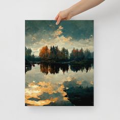 a person holding up a painting with clouds and trees in the background