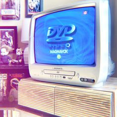 an old tv sitting on top of a wooden shelf