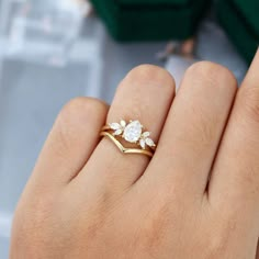 a woman's hand with a gold ring and diamond set in the middle, on top of her finger