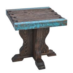 an old wooden table with blue pattered paint on the top and legs, against a white background