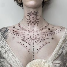 a woman with a tattoo on her chest holding a white flower