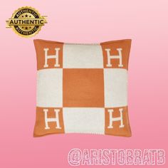 an orange and white checkerboard pillow with the words hh on it's side