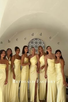 a group of women in yellow dresses standing next to each other