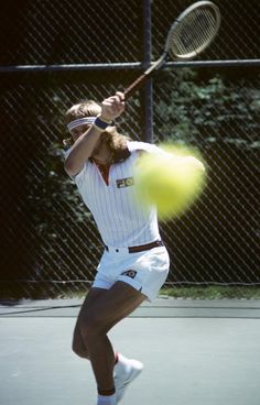 a man swinging a tennis racquet at a ball