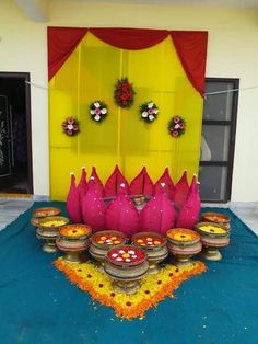 a table topped with lots of food next to a yellow door covered in flowers and wreaths