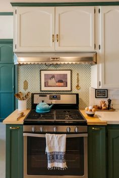 a stove top oven sitting inside of a kitchen next to green cabinets and counter tops