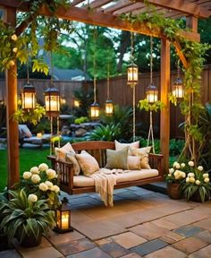 a wooden bench sitting under a pergoline covered arbor with hanging lanterns and flowers