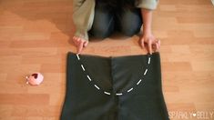 a woman is sitting on the floor with her sewing project