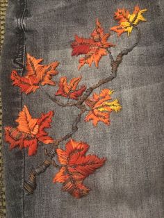 a pair of jeans with orange and yellow flowers painted on the back of each pocket