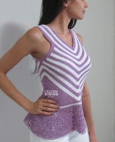 a woman standing in front of a white wall wearing a purple and white tank top