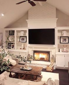 a living room filled with furniture and a flat screen tv mounted on the wall above a fire place