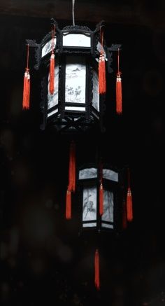 a black and white clock with red tassels hanging from it's sides