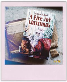 a fire for christmas book sitting on top of a piece of paper next to an old suitcase