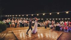 a bride and groom dancing on the dance floor at their wedding reception in front of an audience