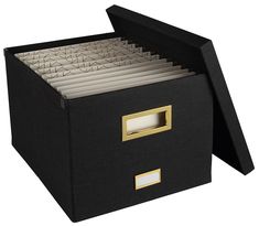 a black file box with gold handles and drawers on the bottom is open to show files