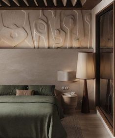 a bedroom with a bed, lamp and artwork on the wall above it's headboard